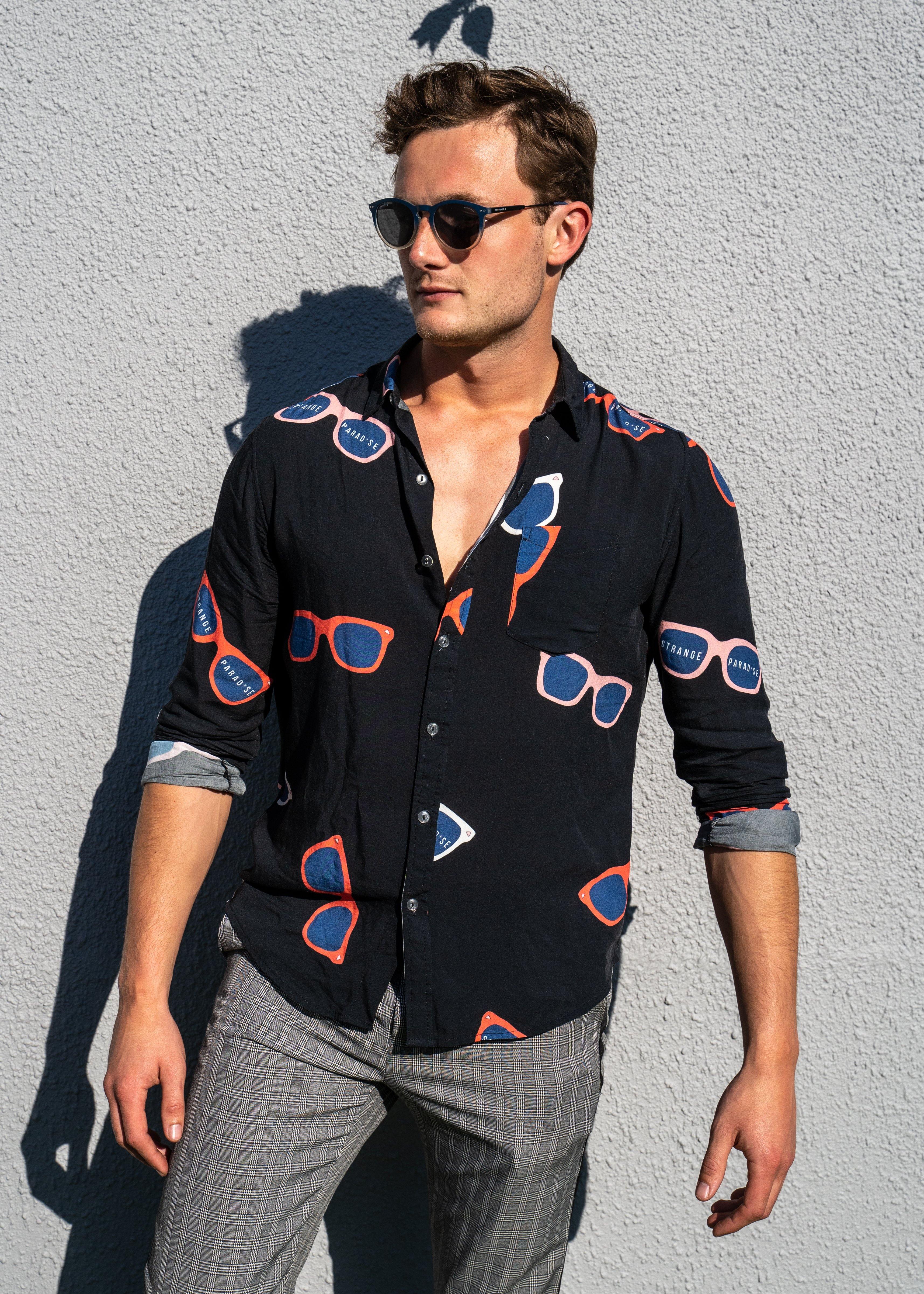 Long Sleeve Shirt - Retro ShadesStrange ParadiseStrange Paradise
Men's Long Sleeve Shirt - Retro Shades is a slim fit shirt with button up fastening and a single chest pocket. The shirt showcases a smart casual look and is pairedMen's Long Sleeve Shirt - Retro Shades