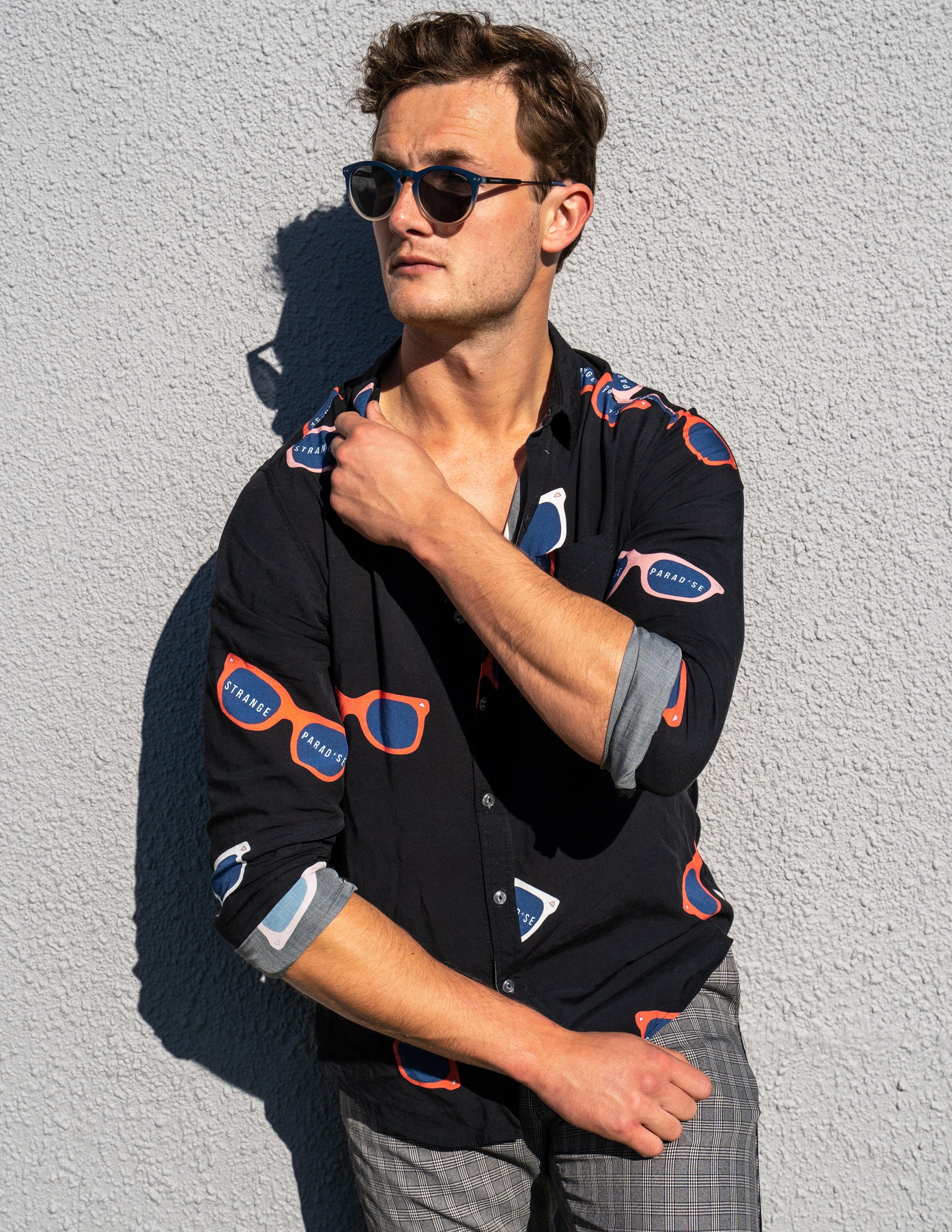 Long Sleeve Shirt - Retro ShadesStrange ParadiseStrange Paradise
Men's Long Sleeve Shirt - Retro Shades is a slim fit shirt with button up fastening and a single chest pocket. The shirt showcases a smart casual look and is pairedMen's Long Sleeve Shirt - Retro Shades